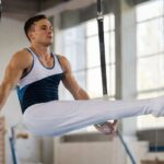 Gymnastics outfit men wear: singlet and stirrup pants on still rings