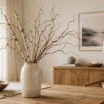 Tall ceramic vase with curly birch pyntekvister branches on a rustic wooden table