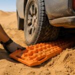 Sandlader placed under a stuck 4x4 tire for vehicle recovery