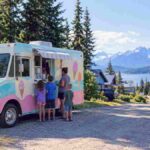 Family enjoying treats from the Jolly Rogers Taste of Paradise Ice Cream Truck Sterling AK on a gravel road"